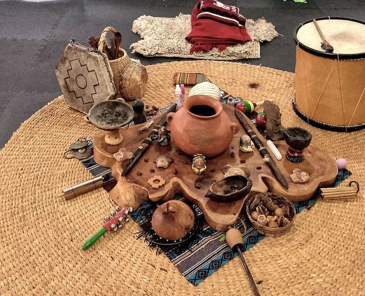 Ayahuasca ceremony setup with traditional instruments and artifacts.