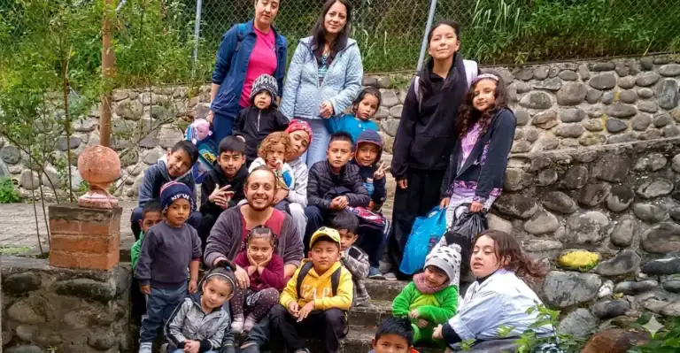 Group of children and adults outdoors at La Pacha Casa de Saberes.